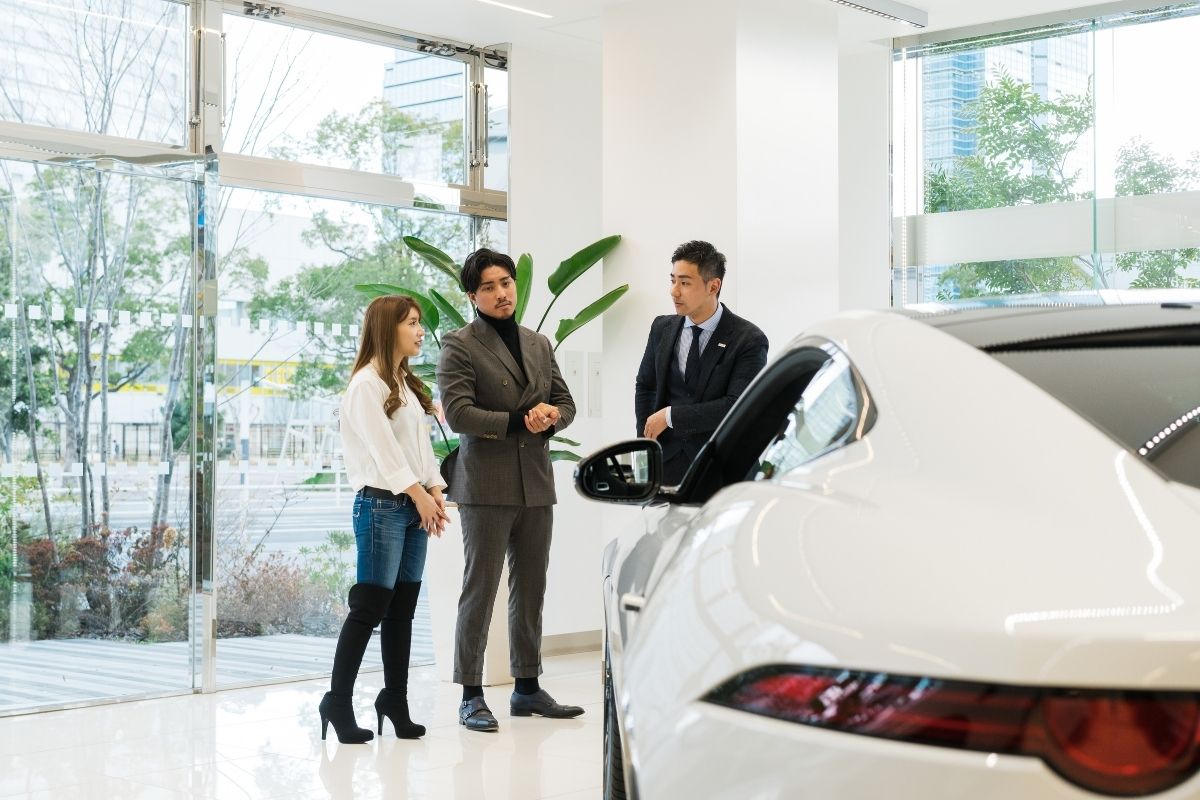 車主在進口車展示中心與業務討論，美國車降價可能影響同價位進口車行情