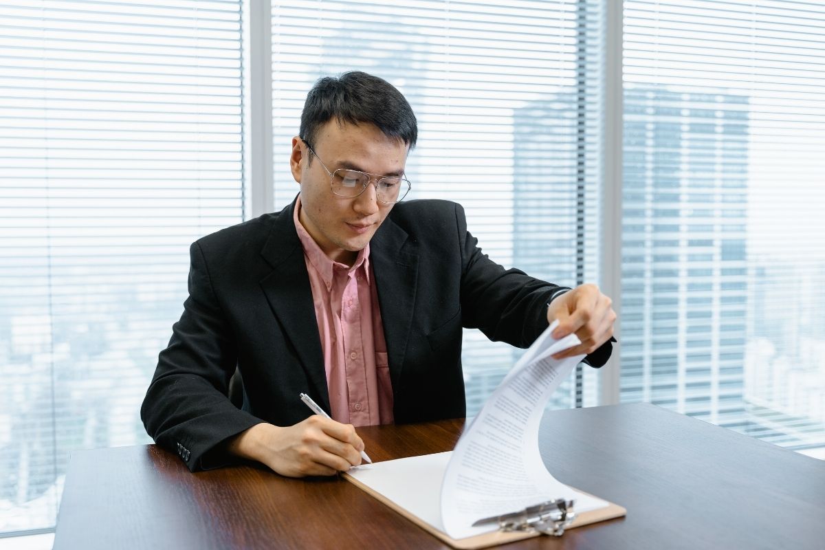 公司主管在辦公室翻閱租賃合約，評估到期買回的營業稅風險