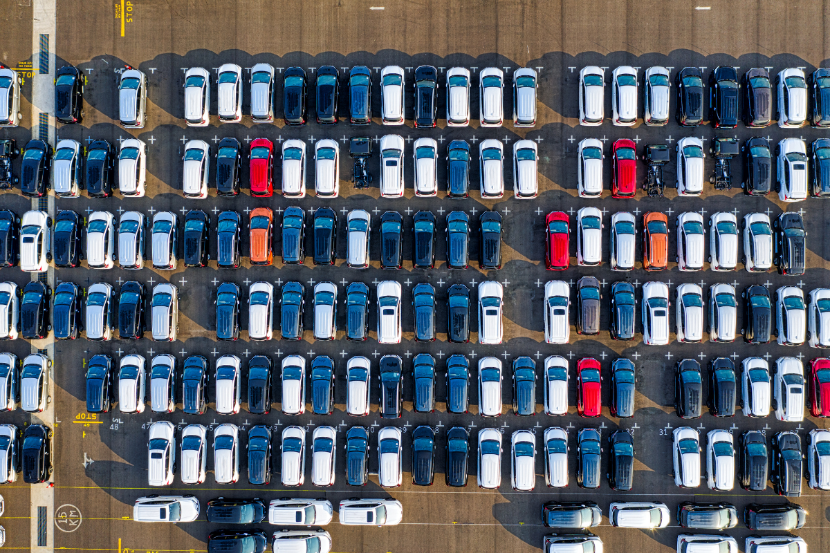 正上方俯拍停車場整排待出貨的新車，汽車關稅調降與美國車零關稅的最新進度